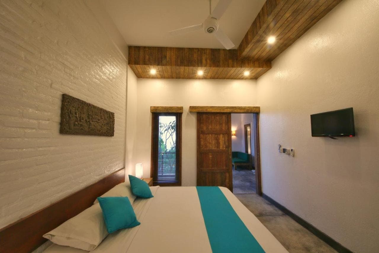 a bedroom with a bed and a tv on the wall at Echoland Boutique Bed And Breakfast in Canggu