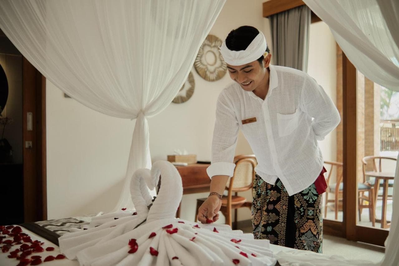 a man is standing next to a cake at Orchid Ubud Cottage in Ubud