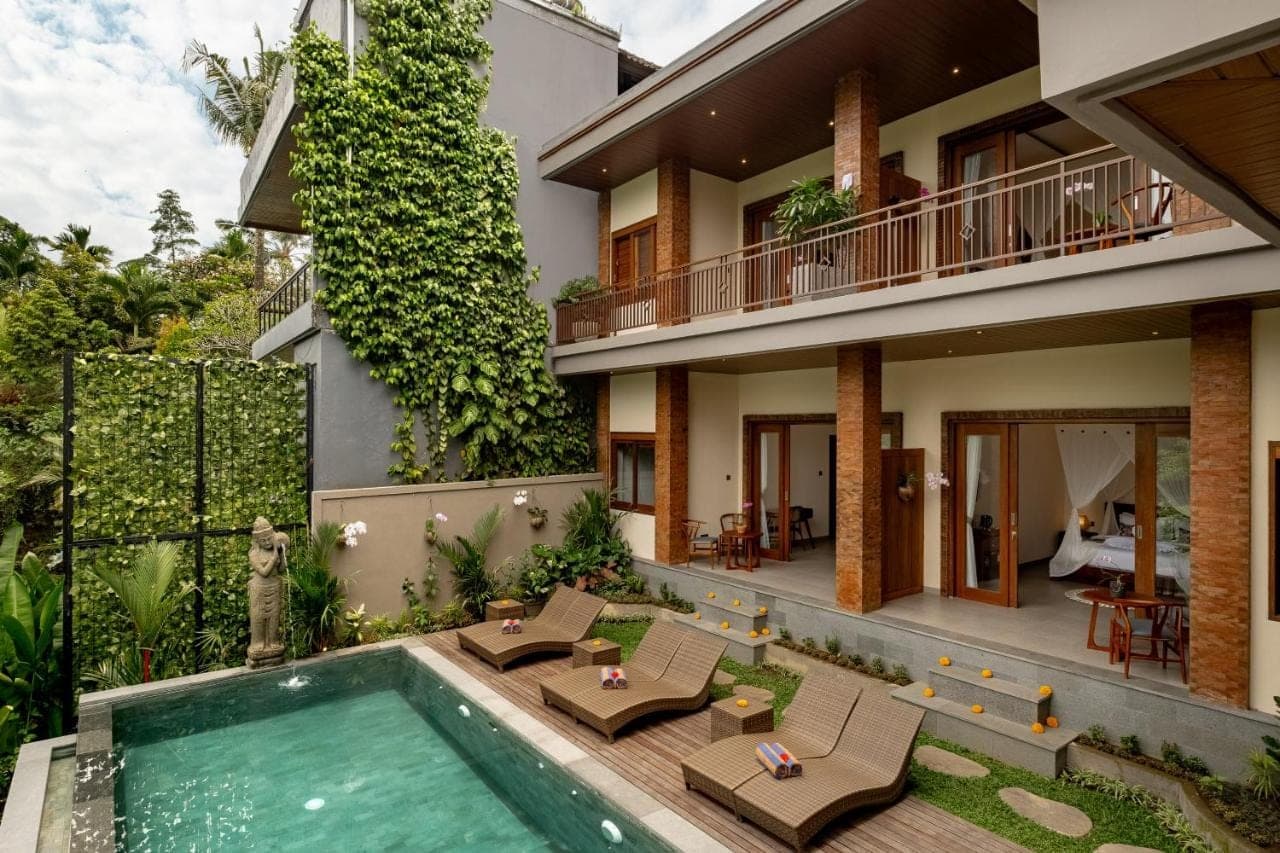an exterior view of a house with a swimming pool at Orchid Ubud Cottage in Ubud