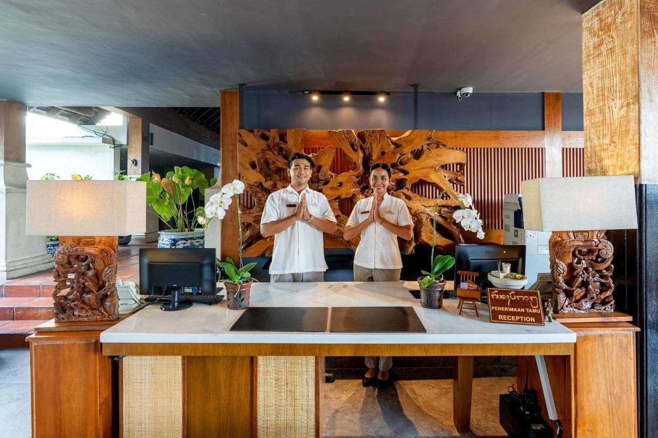 two men standing in front of a mirror at Villa Kayu Raja in Seminyak