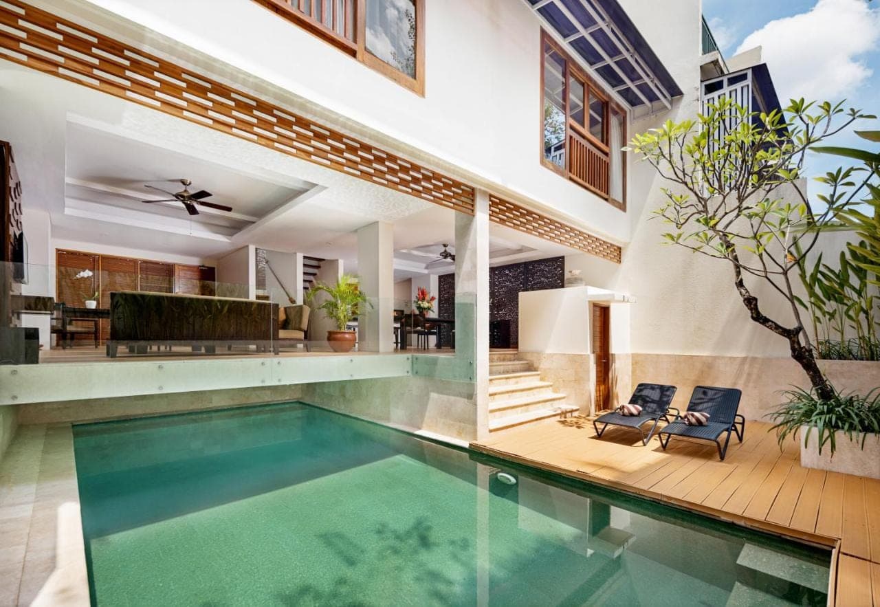 a swimming pool in a house with a house at Villa Kayu Raja in Seminyak
