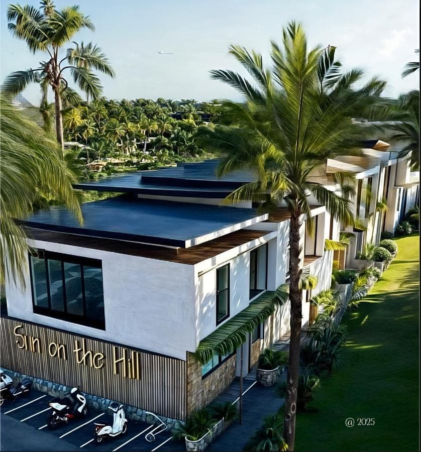 an aerial view of a building with palm trees at Sun on The Hill By Betterplace in Nusa Dua