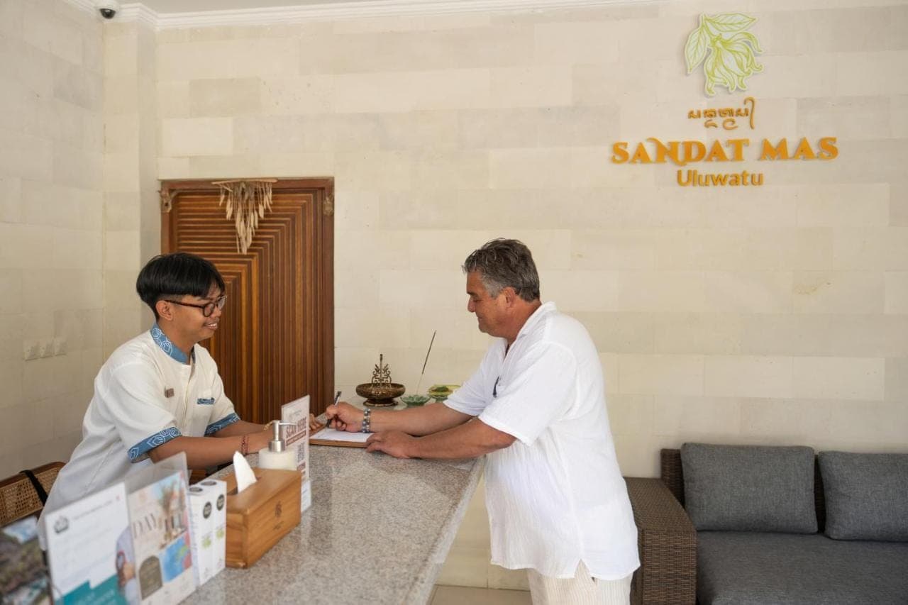 two men standing at a counter in a room at Sandat Mas Uluwatu in Uluwatu