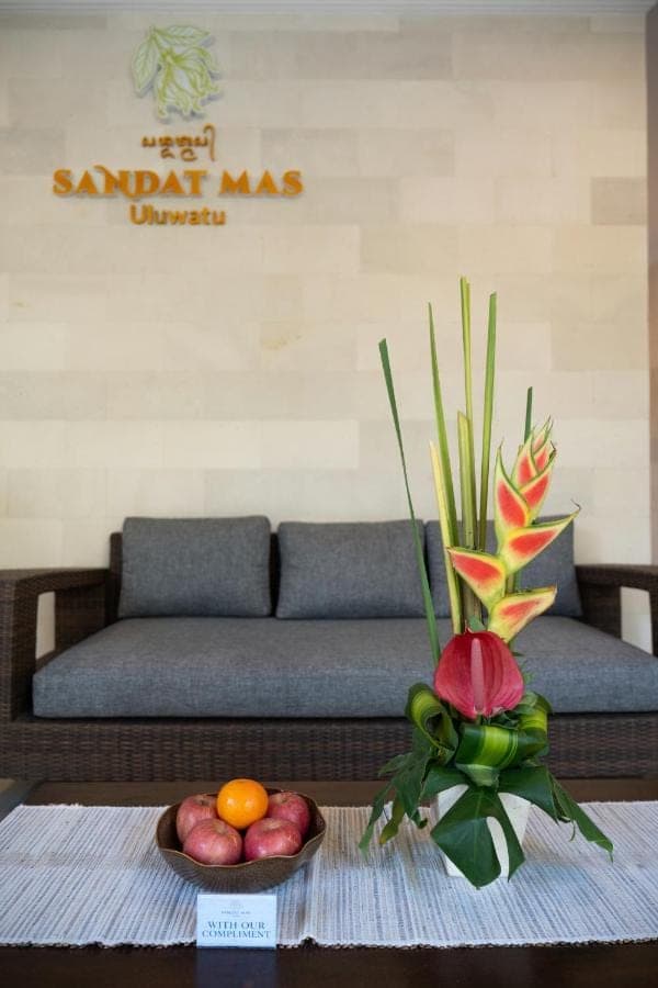 a living room with a couch and a table with a bowl of fruit at Sandat Mas Uluwatu in Uluwatu