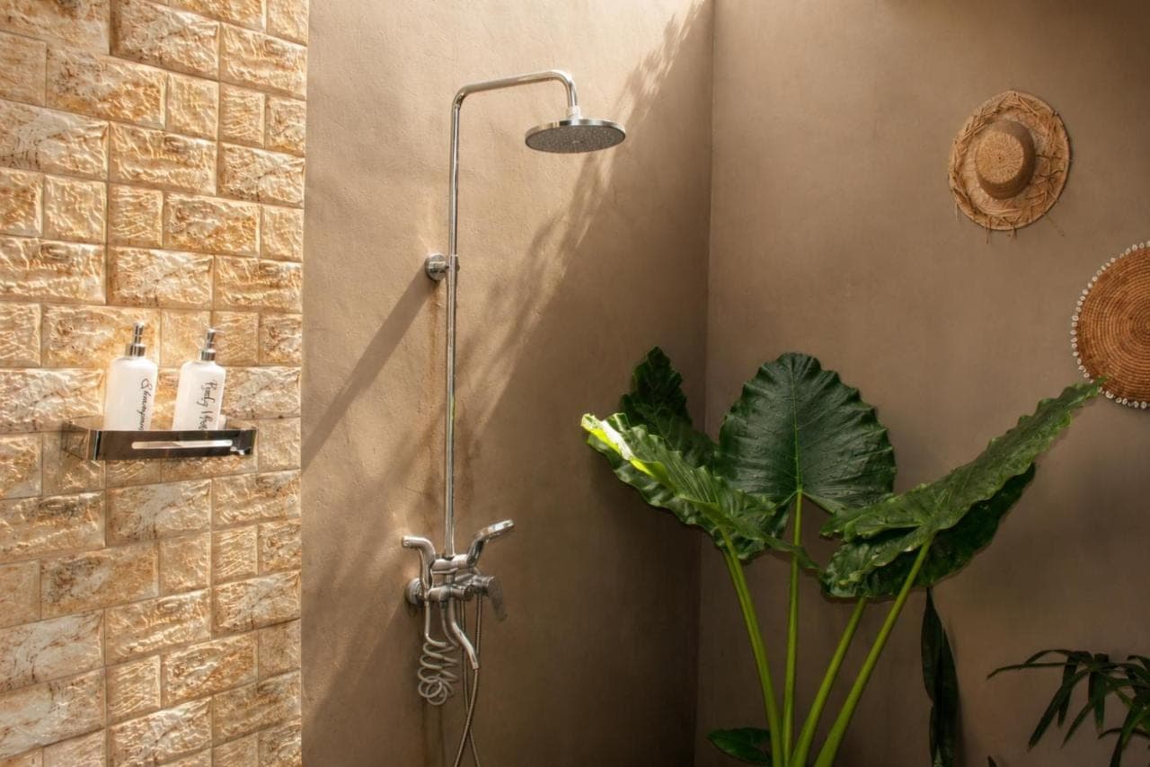 a shower in a bathroom with a plant at Papahan Bali in Sidemen