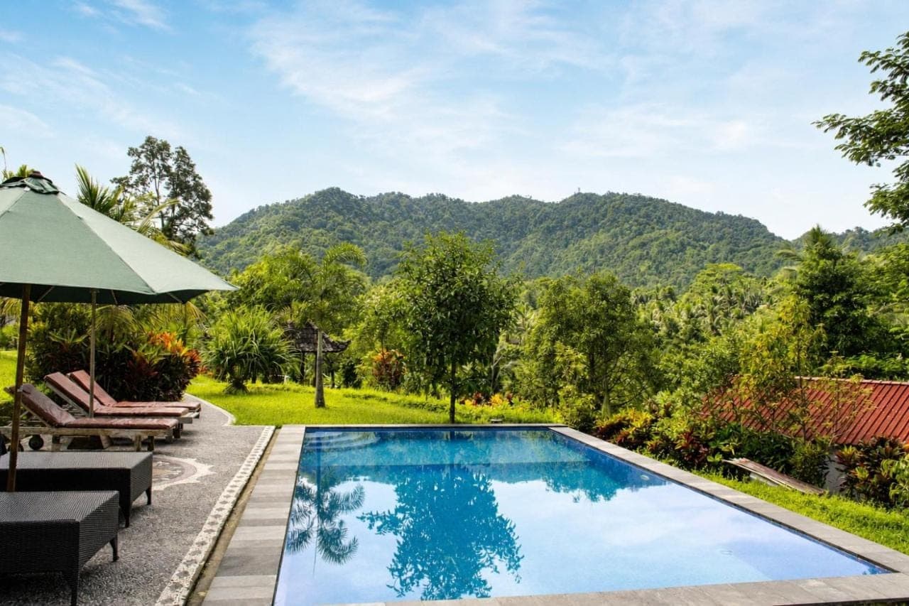 a swimming pool with a view of a mountain at Papahan Bali in Sidemen