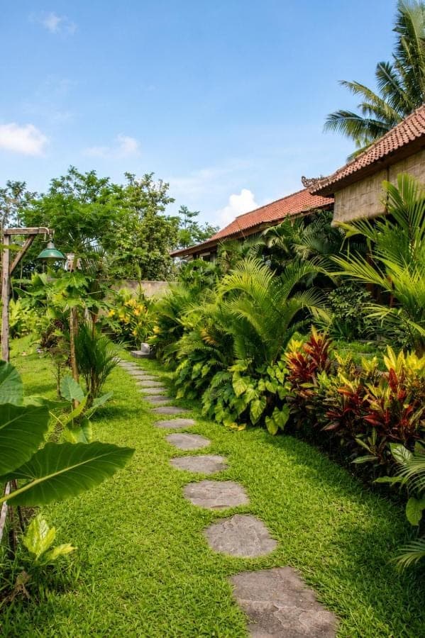 a path through a garden in front of a house at Papahan Bali in Sidemen