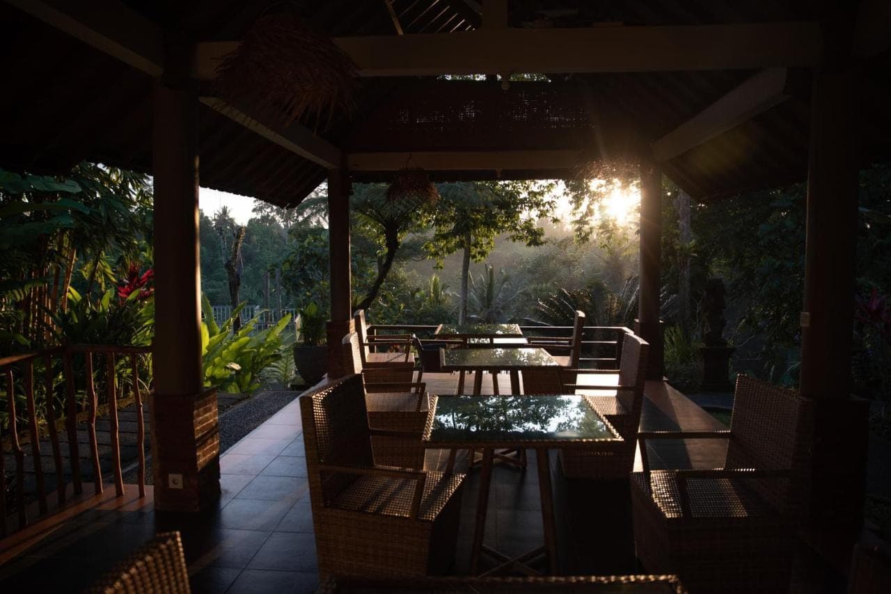 a restaurant with tables and chairs on a patio at Angsoka Bungalow in Ubud