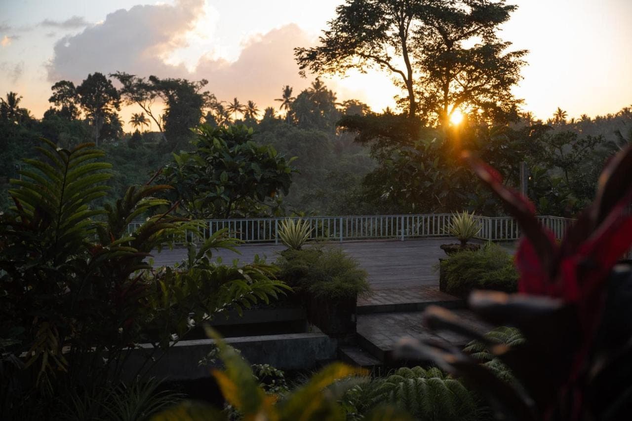 a sunset over a bridge in a garden at Angsoka Bungalow in Ubud