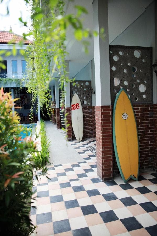 two surfboards are on the wall of a building at Mojosurf Camp Canggu in Canggu