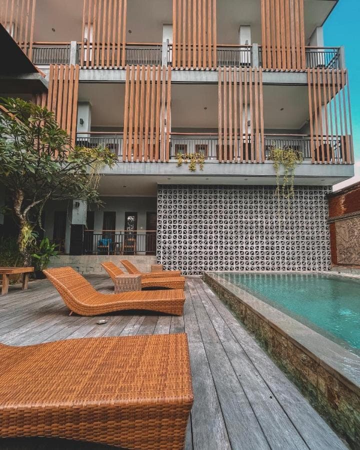 a resort with a pool and some chairs and a building at Perissos Echo Beach in Canggu
