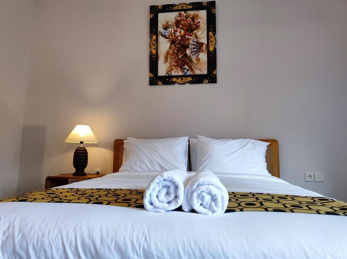a bedroom with a bed with towels on it at Vinandaka Homestay in Sanur