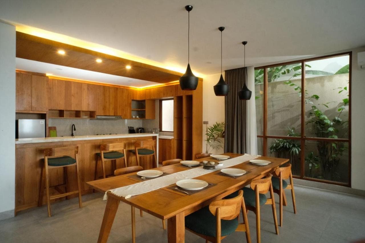 a large wooden table in a kitchen with chairs at The Ledge Uluwatu in Uluwatu