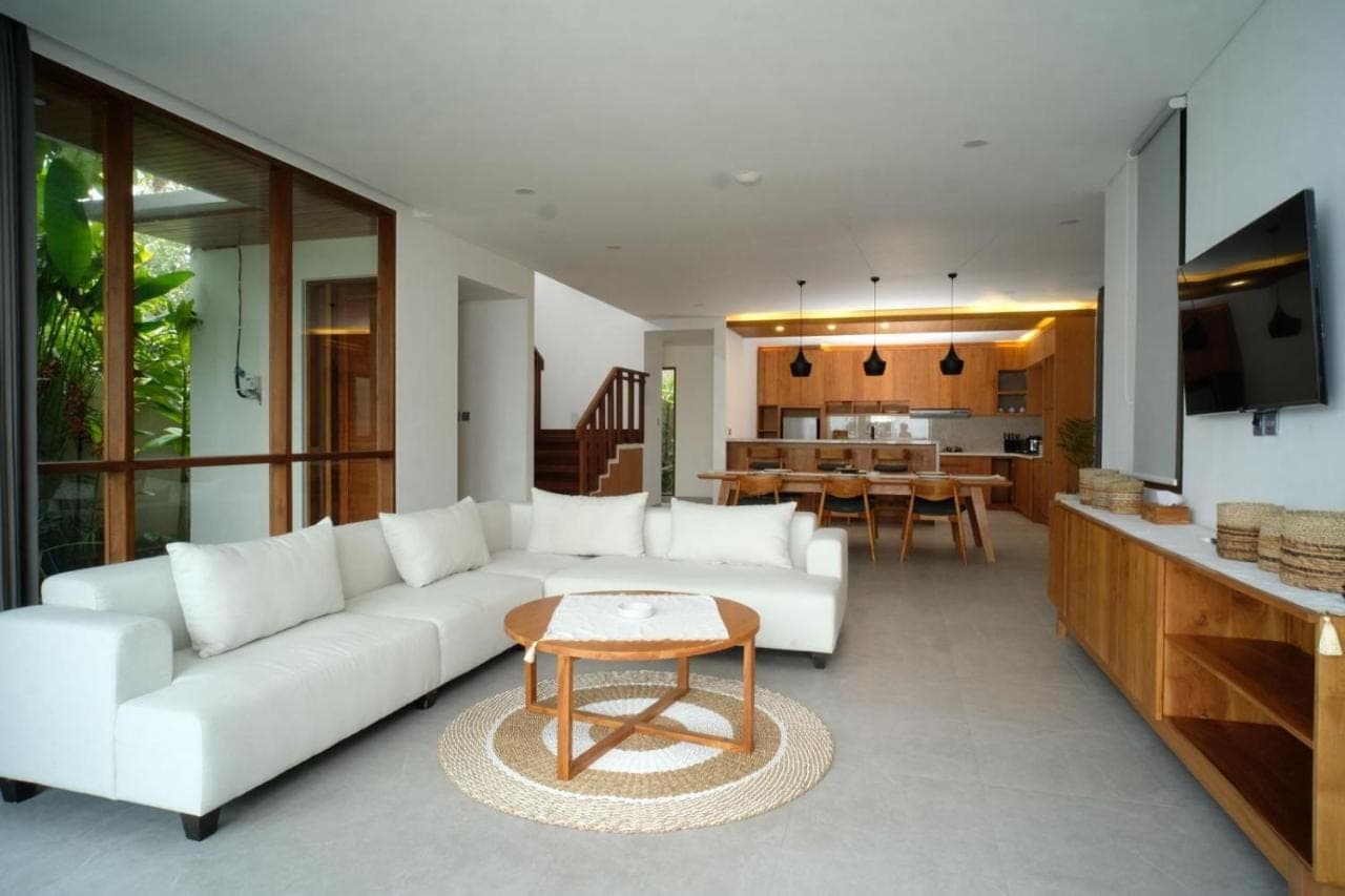 a living room with a white couch and a table at The Ledge Uluwatu in Uluwatu