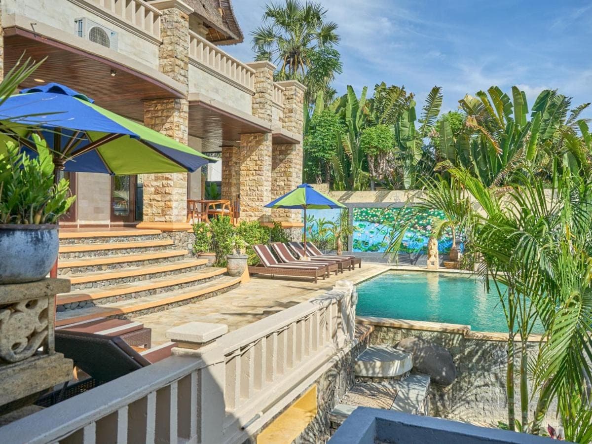 a house with a swimming pool with chairs and umbrellas at Onlyou Villas in Amed