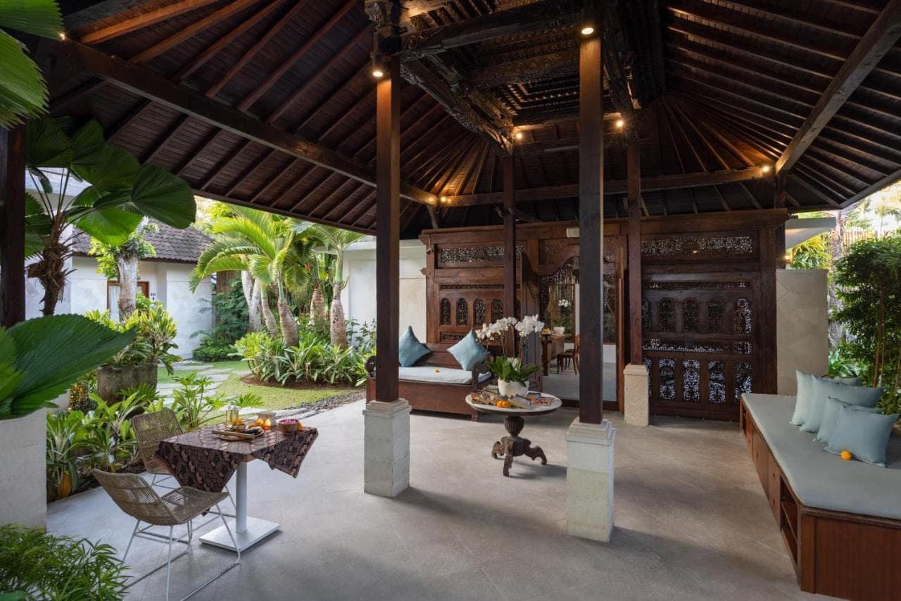 an outdoor patio with a large wooden pergola at Tapa Tepi Kali Canggu in Canggu