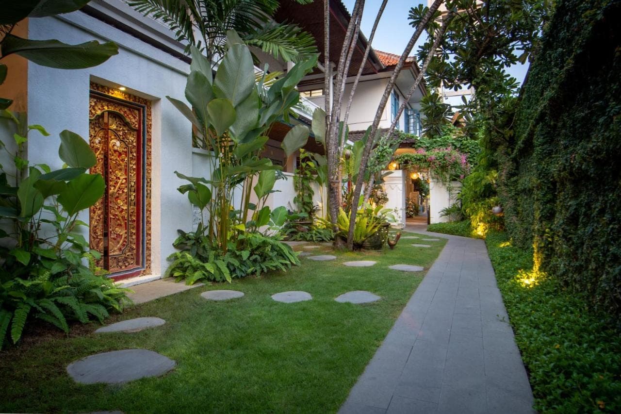 a garden with a walkway in front of a house at Sanur House in Sanur