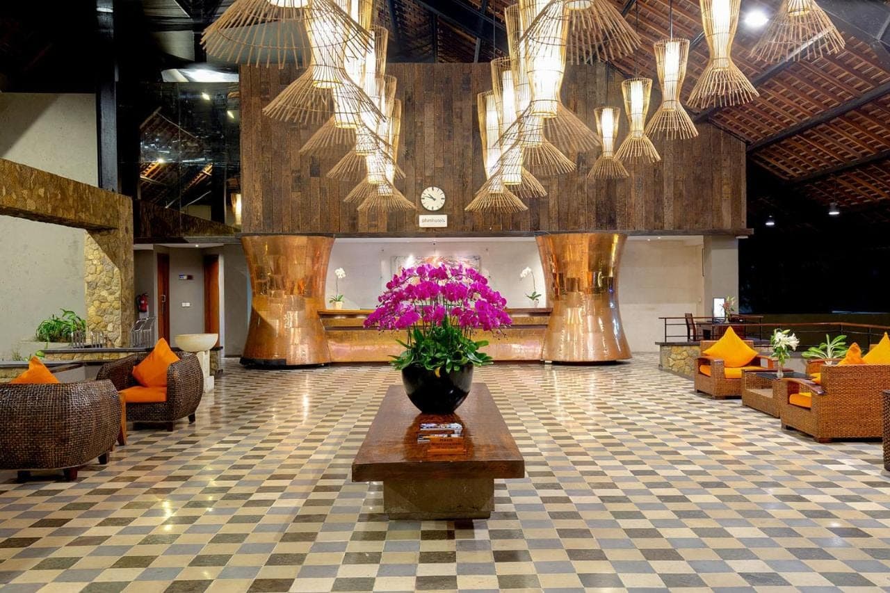 a lobby with a vase with purple flowers on a table at THE 1O1 Bali Oasis Sanur in Sanur