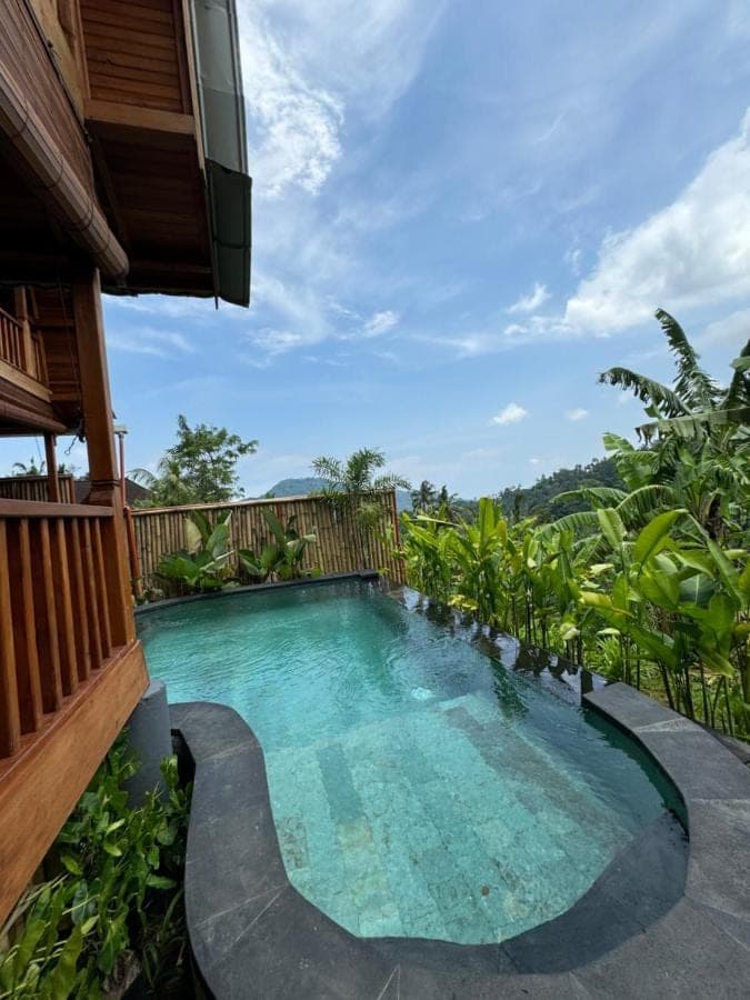 a swimming pool in the middle of a house at Lumbung Kembar Sidemen in Sidemen