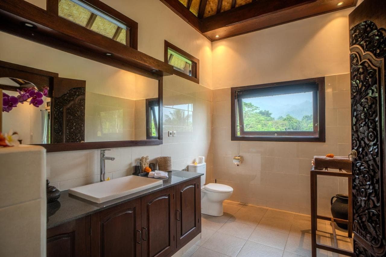 a bathroom with a sink and a toilet and a window at Green Hill Bungalows in Sidemen