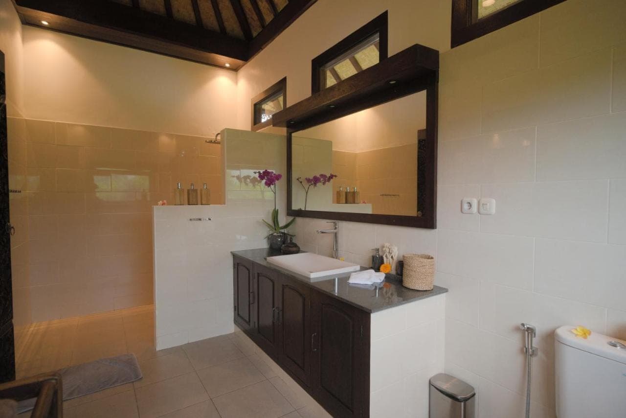 a bathroom with a sink and a mirror and a tub at Green Hill Bungalows in Sidemen
