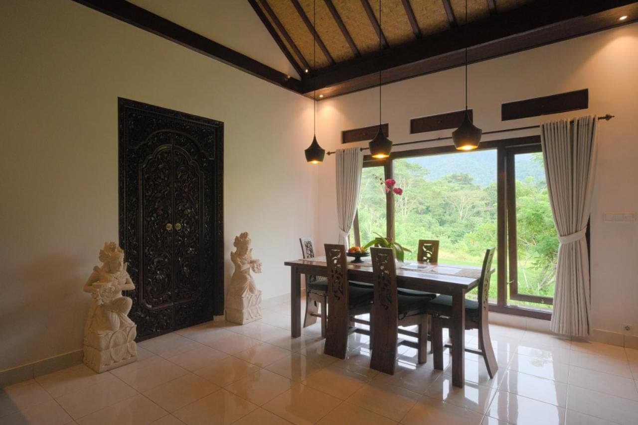 a dining room with a table and a large window at Green Hill Bungalows in Sidemen