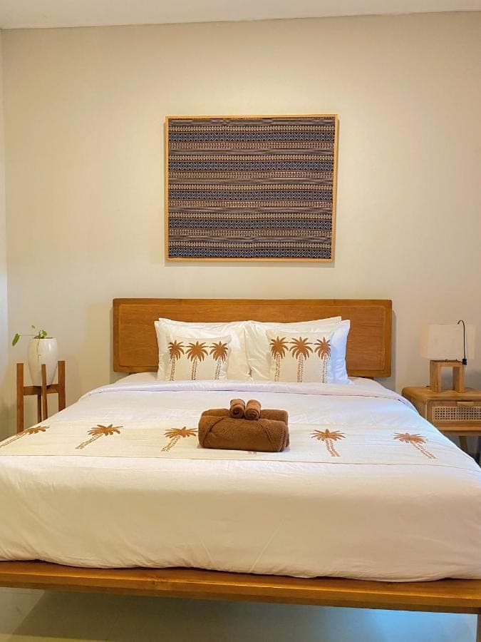 a bed with a brown bag on top of it at Nita Villa Bali in Canggu
