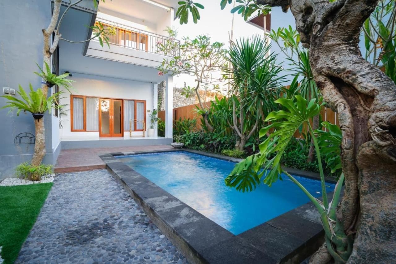 a swimming pool in front of a house at La Tierra Canggu in Canggu