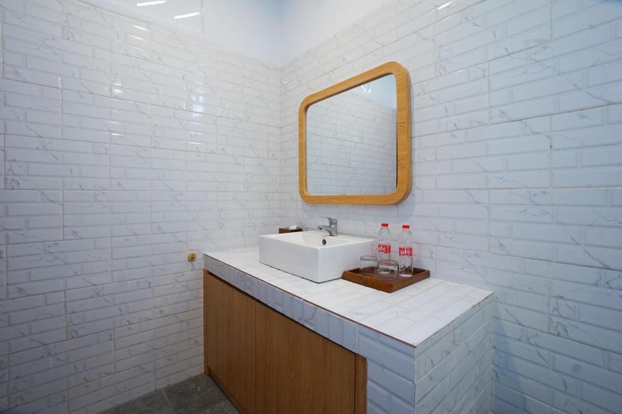 a white bathroom with a sink and a mirror at La Tierra Canggu in Canggu