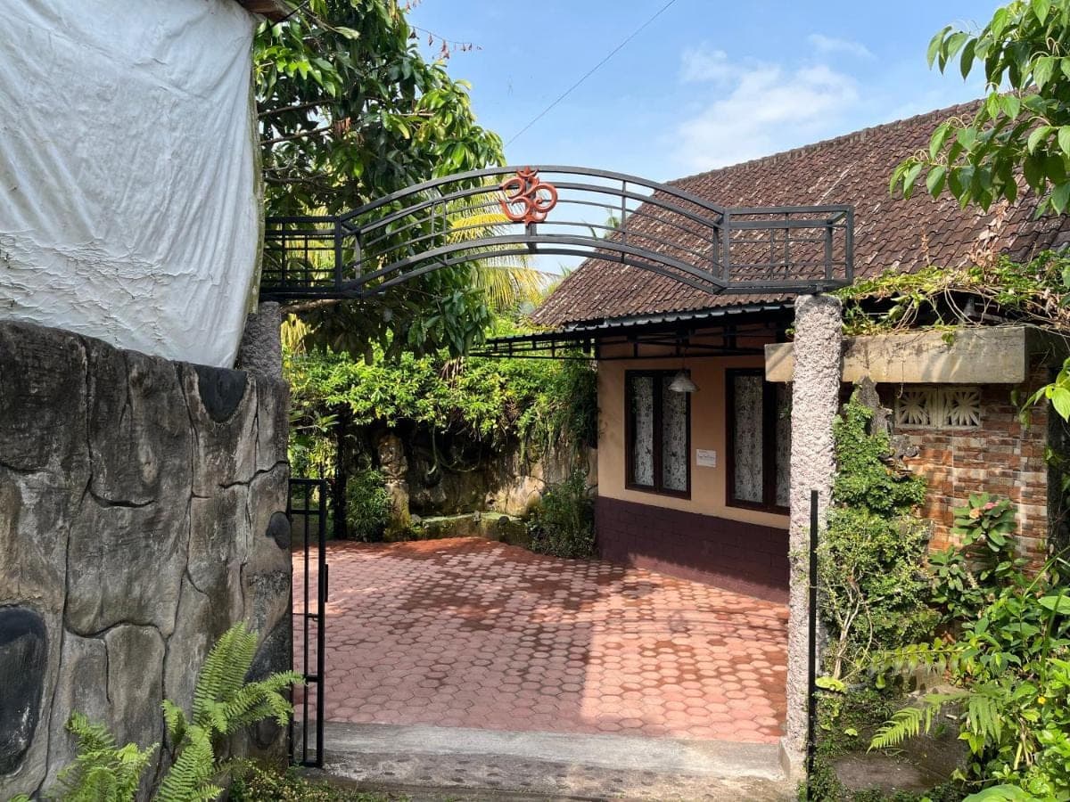 a gate to a house with a brick driveway at Khrisna Hs and Cottages in Sidemen