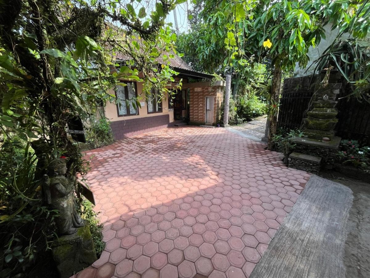 a brick walkway in front of a house with a building at Khrisna Hs and Cottages in Sidemen