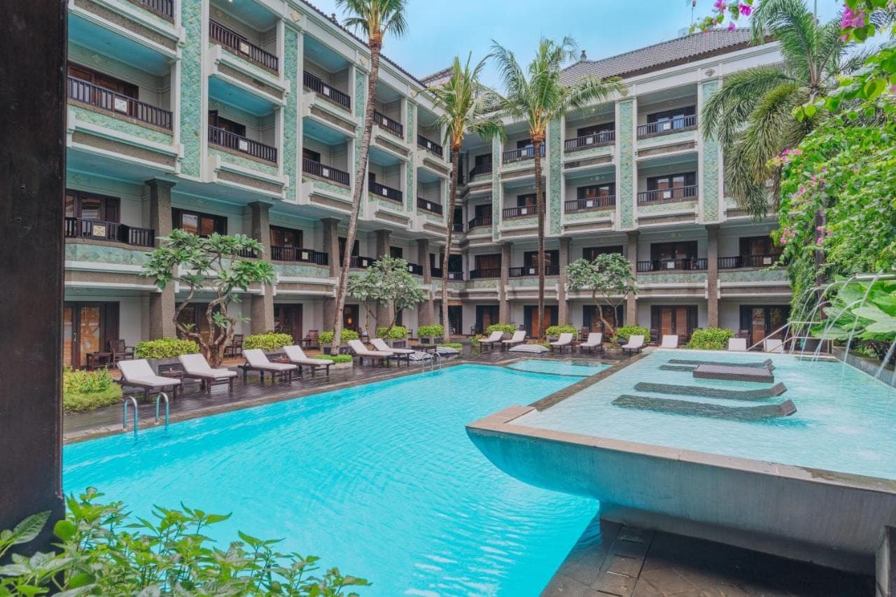 an exterior view of a hotel with a large swimming pool at The Vira Bali Boutique Hotel &amp; Suite in Kuta