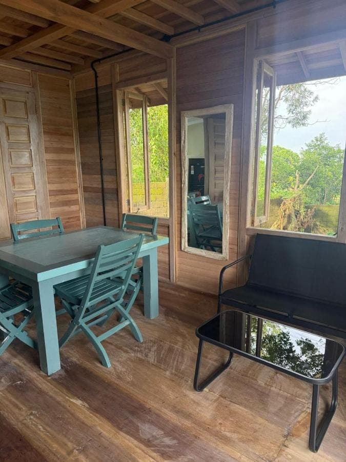a dining room with a table and chairs and a bench at Villa Anjing 2 in Nusa Dua