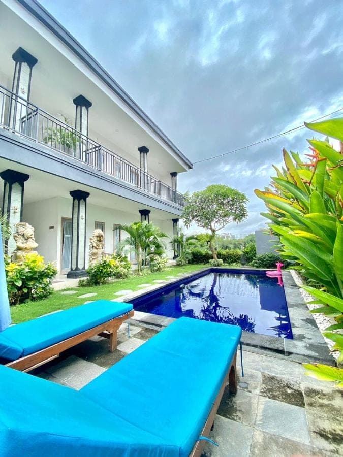 a villa with a swimming pool and a house at Eva Guest House in Canggu