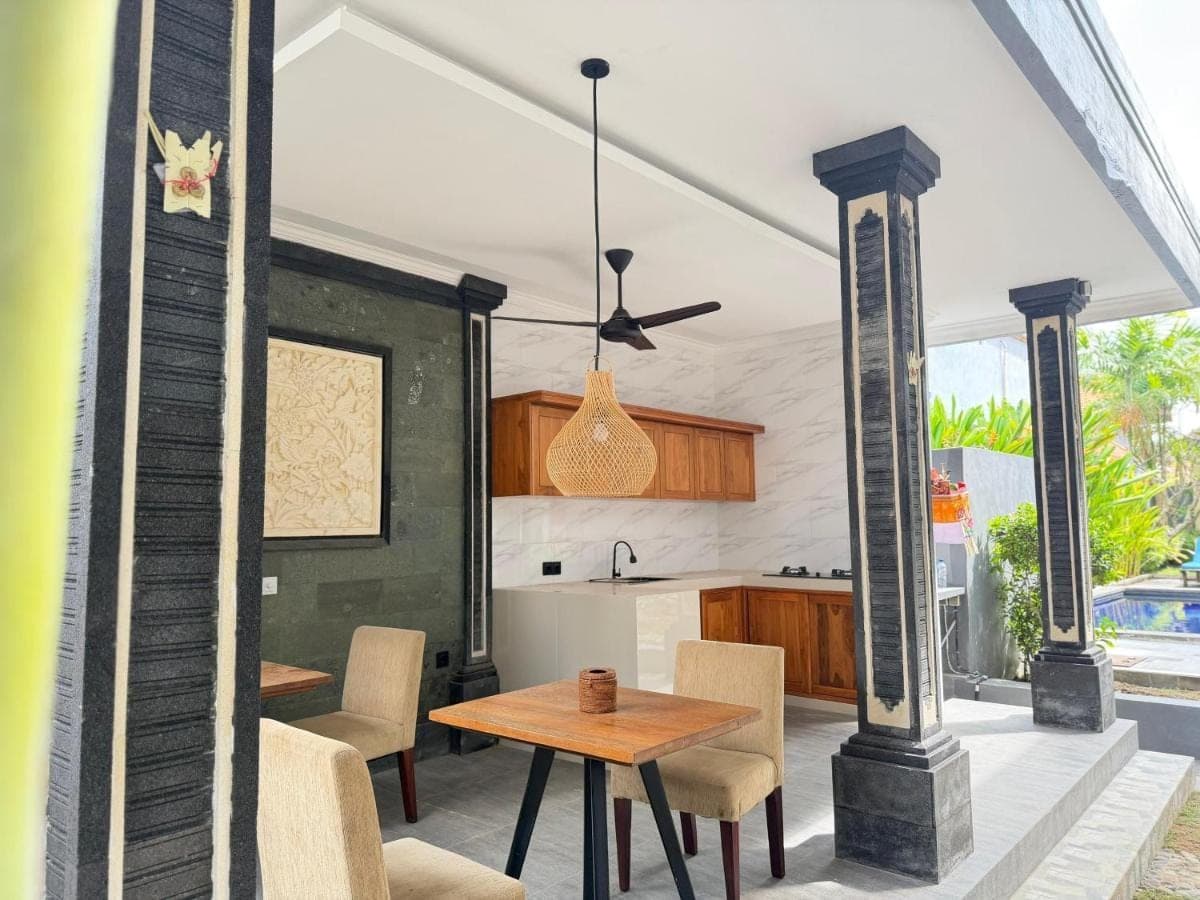 a kitchen and dining area with a table and chairs at Eva Guest House in Canggu