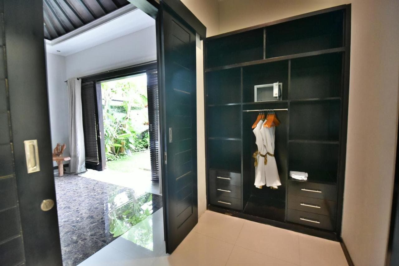a dressing room with green walls and a mirror at Katala Suites and Villas in Sanur