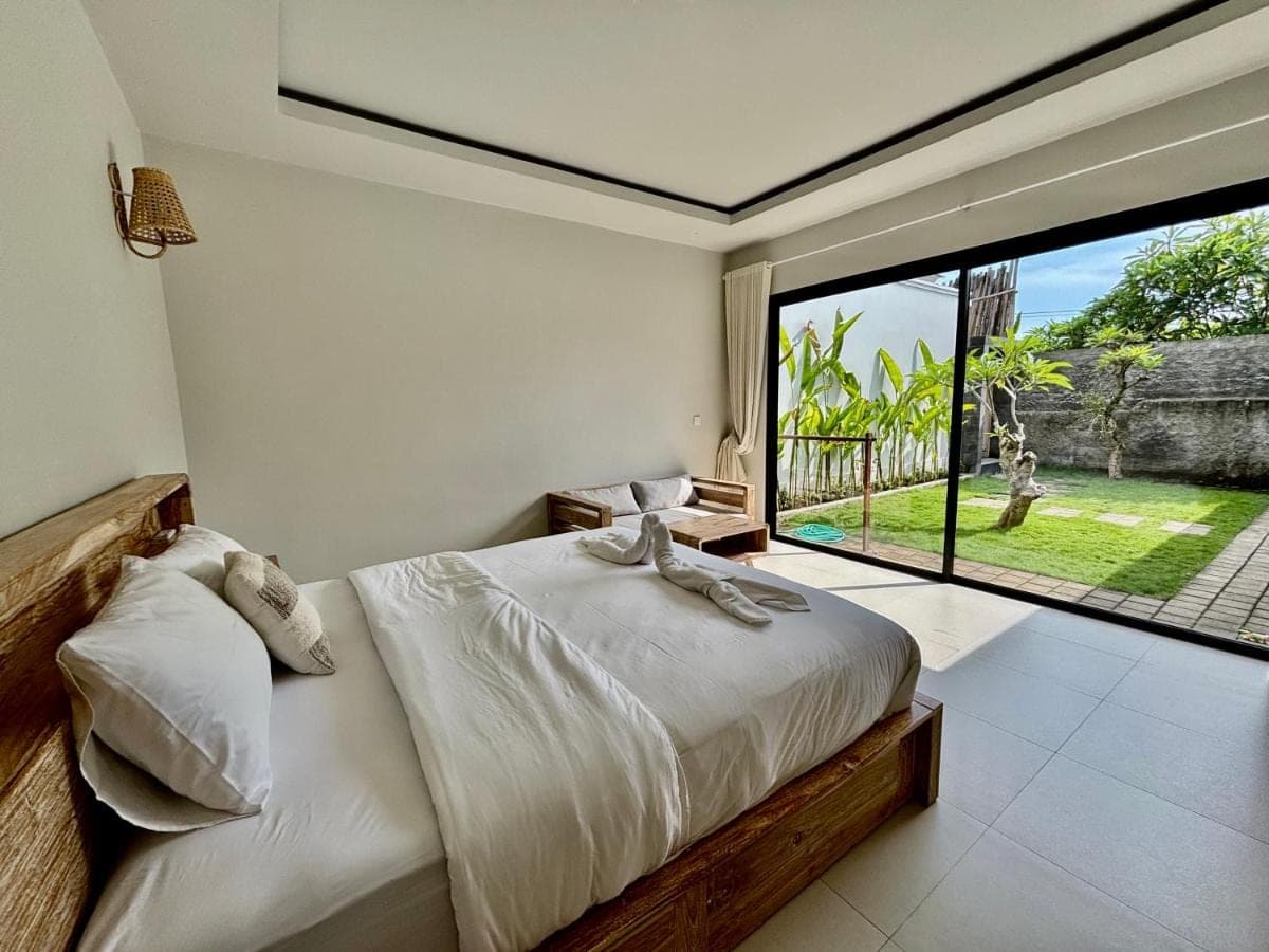 a bedroom with a bed and a large window at Lipah Beach Private Villas in Amed