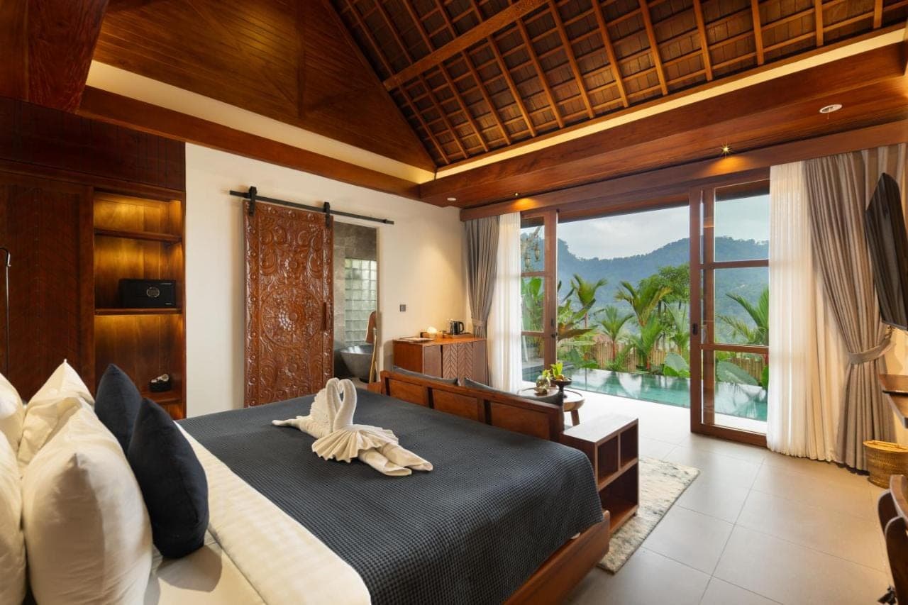 a bedroom with a large bed and a large window at Kankhara Villas Sidemen in Sidemen