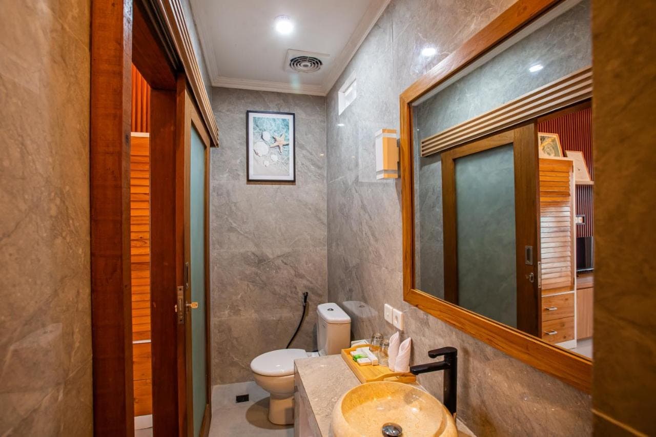 a bathroom with a sink and a toilet and a mirror at Surf Lodge Canggu in Canggu