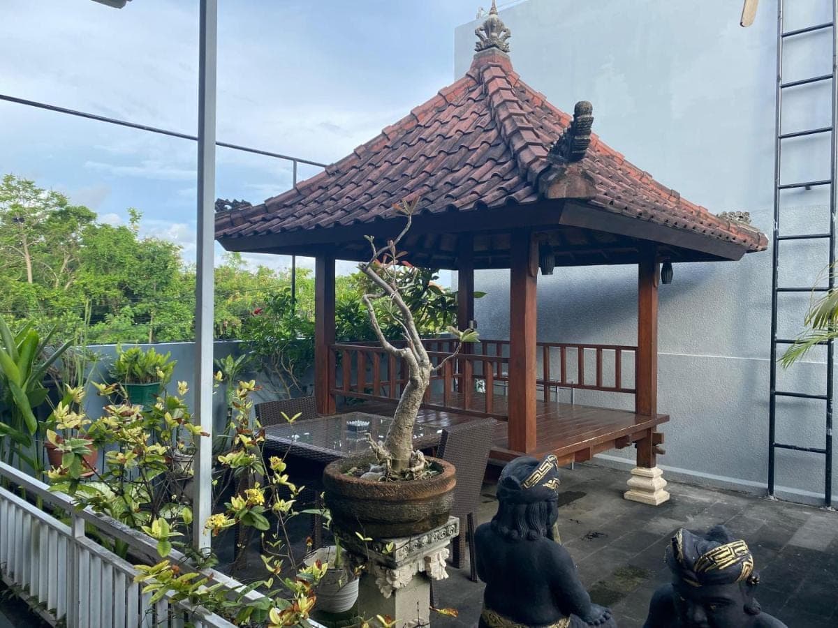 a gazebo on a balcony with a tree in a pot at Dikubu Belong Seminyak in Seminyak