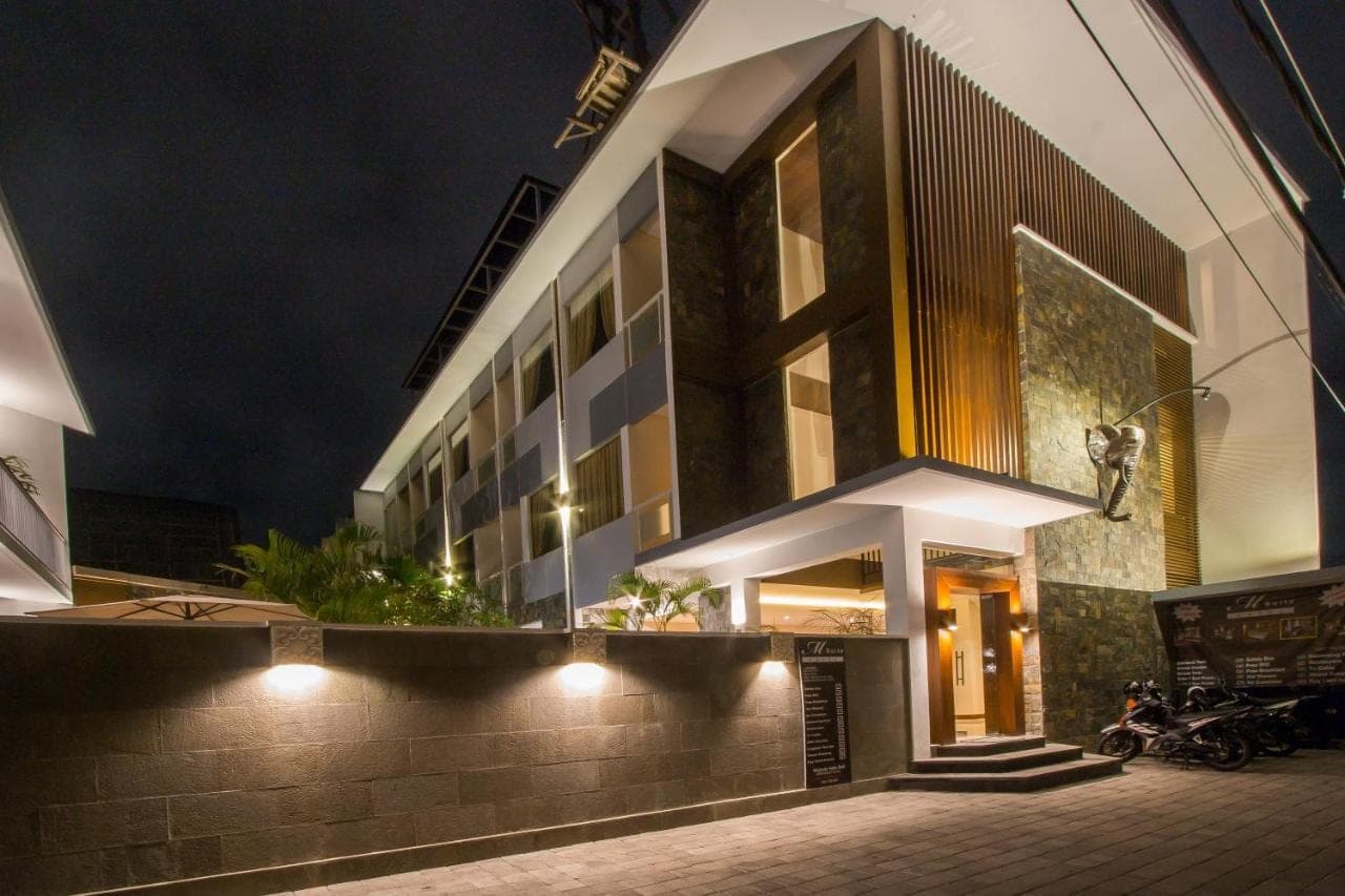 a building with lights on the side of it at night at M Suite Bali in Seminyak