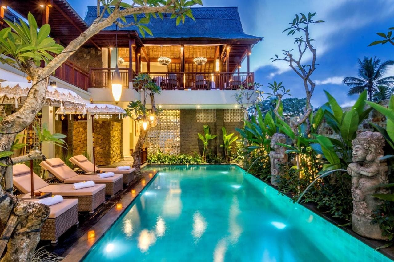 a villa with a swimming pool in front of a house at Bumi Muwa Ubud Katiklantang in Ubud
