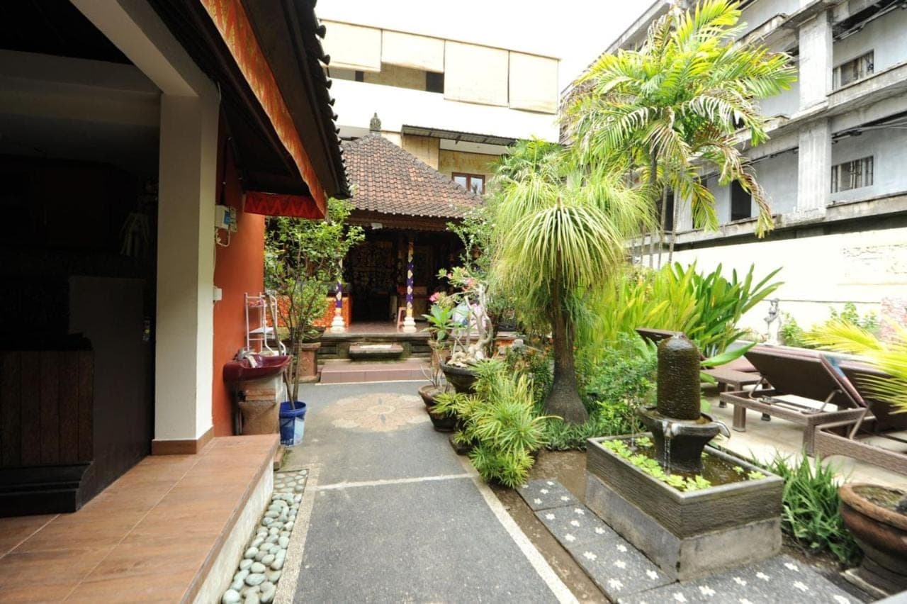 a courtyard of a building with trees and plants at Tori Inn in Sanur