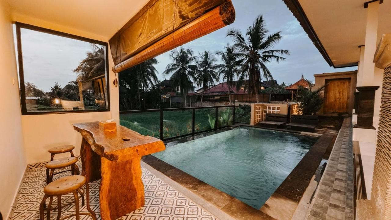 a small swimming pool with a table and chairs on a patio at Uma Mesari Ubud in Ubud