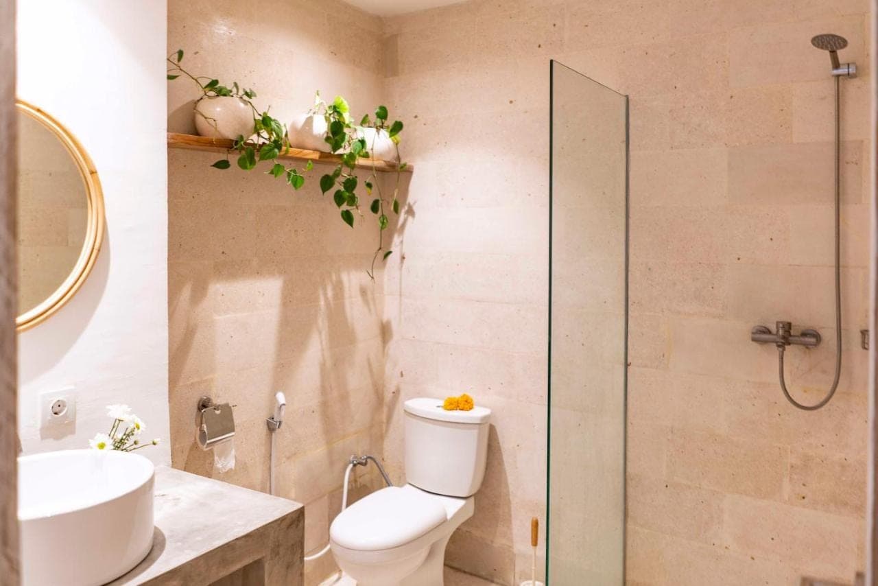 a bathroom with a toilet and a sink and a shower at Eden Garden Villa Canggu in Canggu