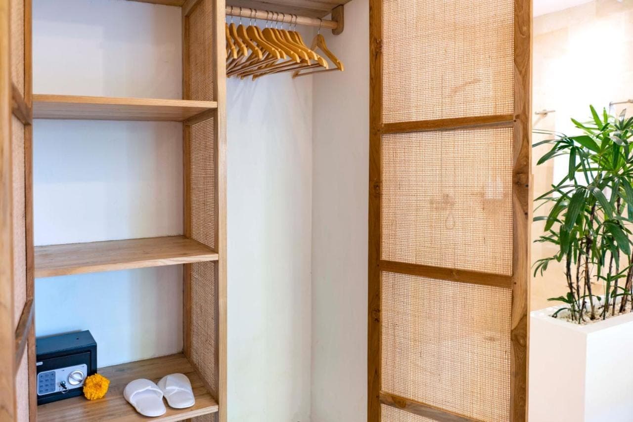 a closet with wooden shelves and a plant at Eden Garden Villa Canggu in Canggu