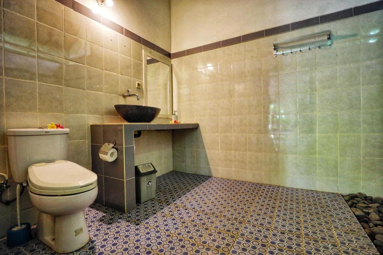 a bathroom with a toilet and a sink at Kirana Homestay in Amed