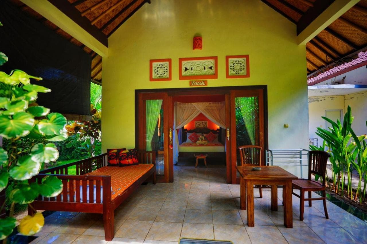 a living room with benches and a fish tank at Kirana Homestay in Amed