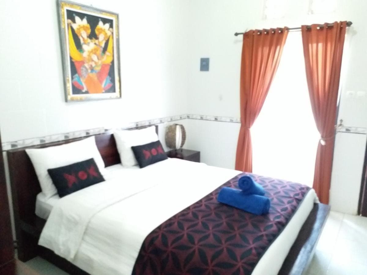 a bedroom with a bed with a blue object on it at Jepun Segara Guest House in Kuta