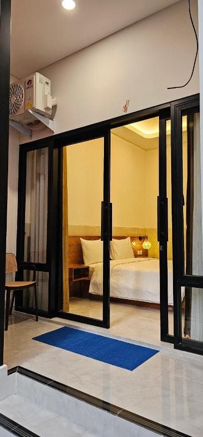 a room with a bed and a glass window at Jepun Segara Guest House in Kuta